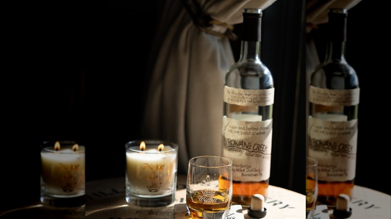 Bottle of Rowan's Creek with glass and candle on barrel