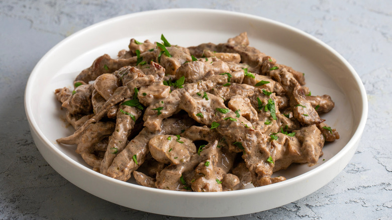 Creamy beef stroganoff with mushrooms in a white bowl