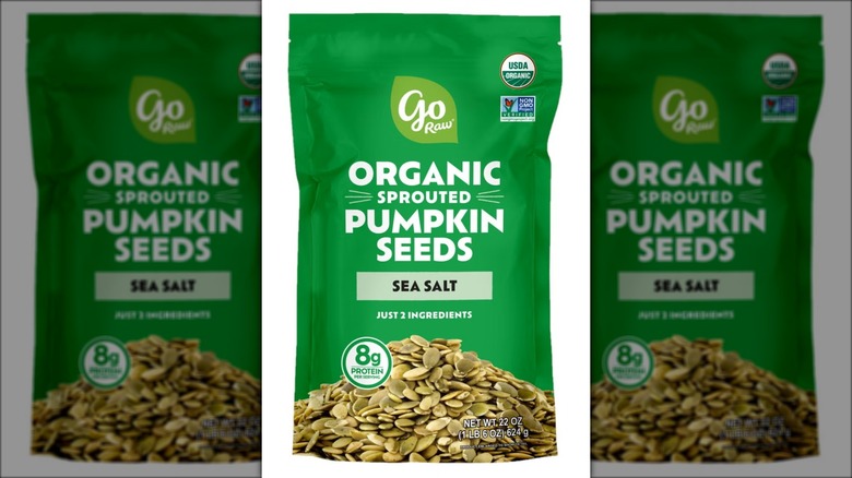 Bag of organic pumpkin seeds against white background.