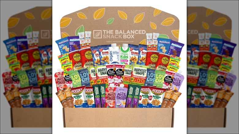 Large variety box of healthy snacks against white background.