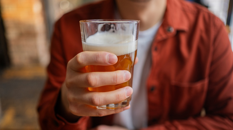 man holding pint of beer