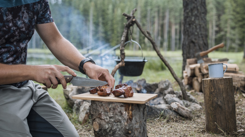 man cooking over camp fire