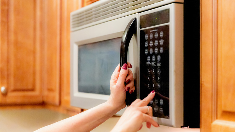 A woman programming her microwave