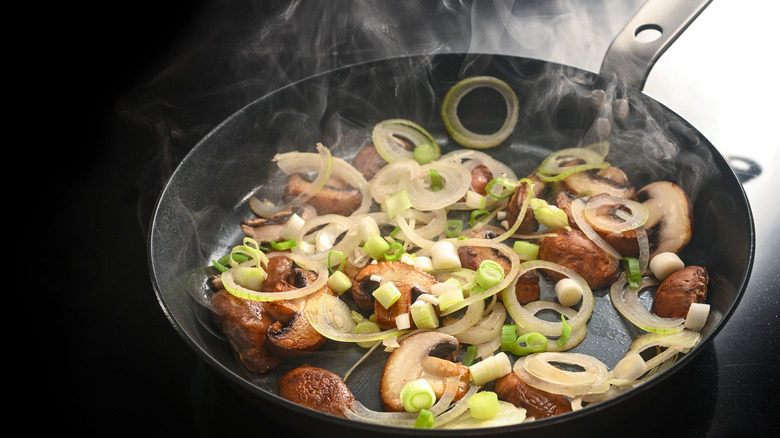 Sliced mushrooms and onion frying in a pan