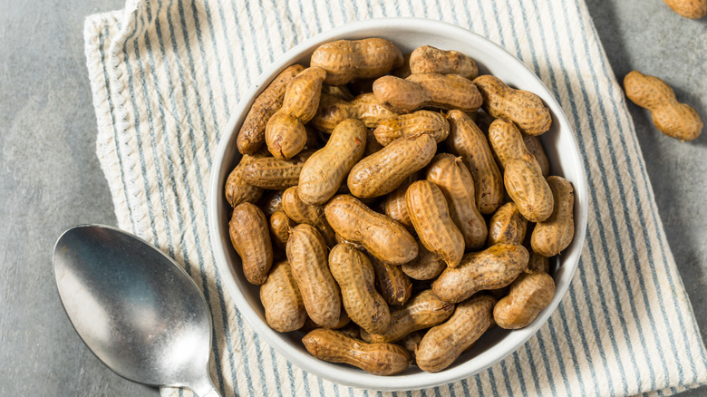 bowl of boiled peanuts on a dishtowel with a spoon next to it