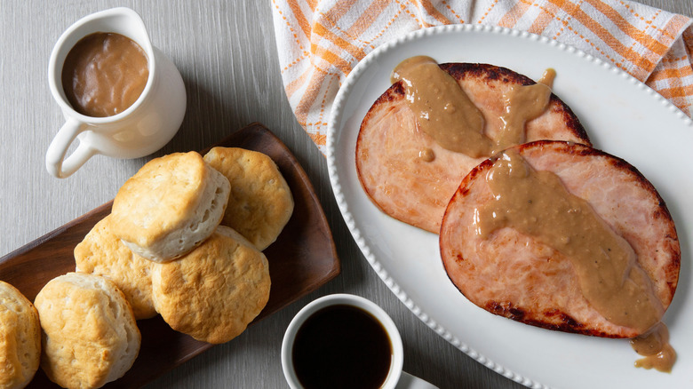 biscuits, ham, and red-eye gravy plated on a table