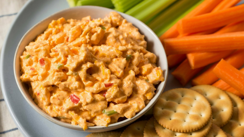 bowl of pimento cheese next to crudite and crackers