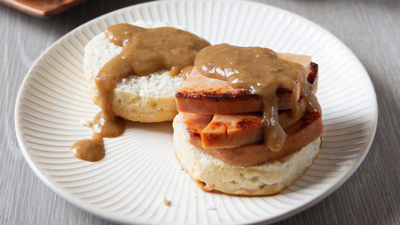 A plate of red-eye gravy and ham on biscuits