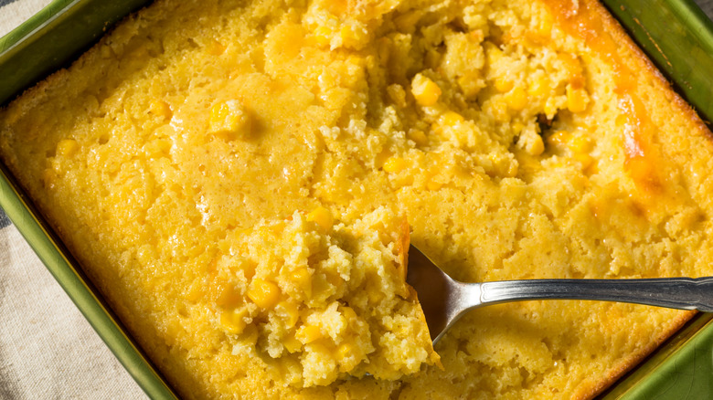 overhead shot of a dish of spoonbread, a serving spoon digging in