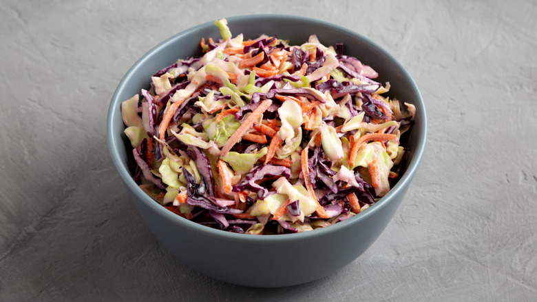 A bowl of coleslaw on a grey background