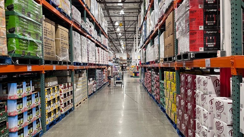 Customer with cart perusing the aisles inside Costco.