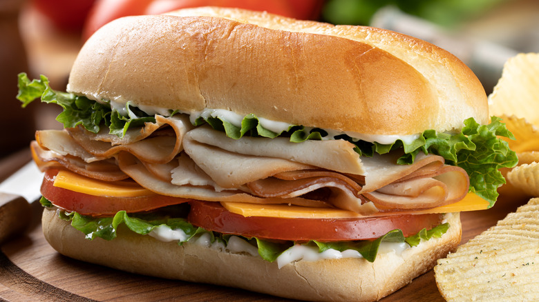 sub sandwich with turkey, lettuce, tomato, cheese, and mayo