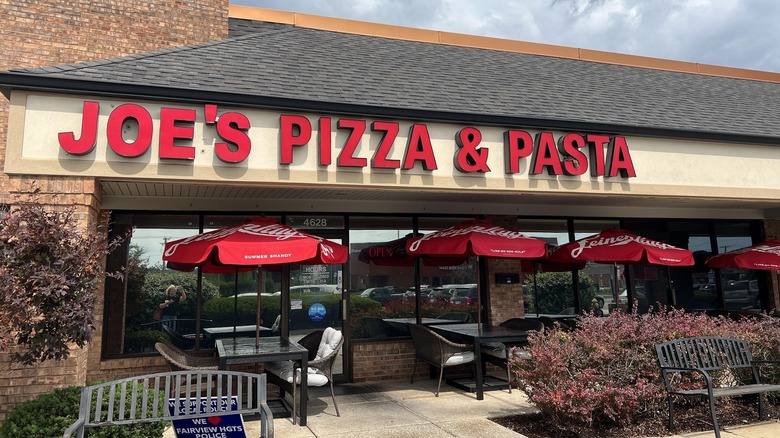 joe's pizza shop exterior with red umbrellas