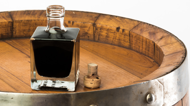 Bottle of balsamic vinegar isolated on a wooden table