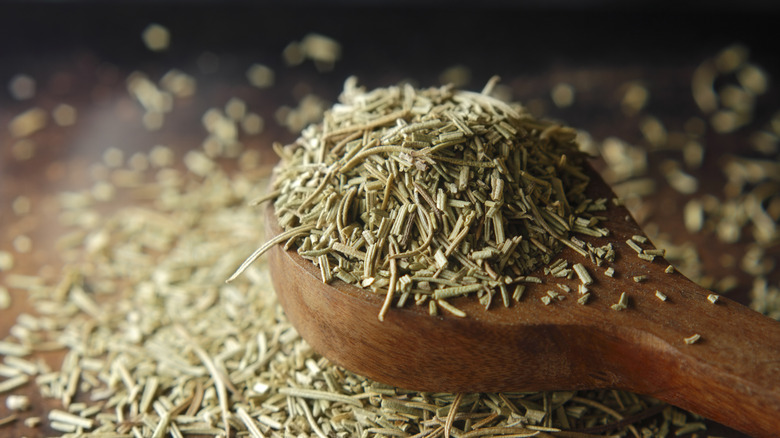 Dried rosemary in a wooden spoon
