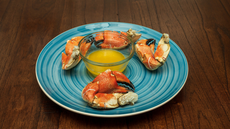 Jonah crab on a blue plate with melted butter