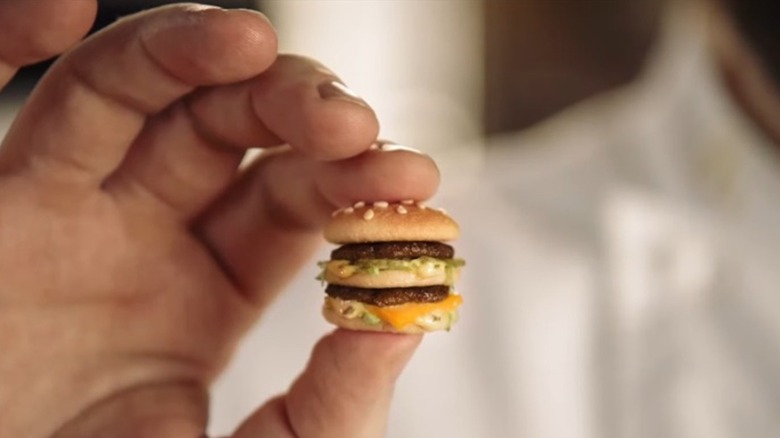 Fingers holding tiny MicroMac burger