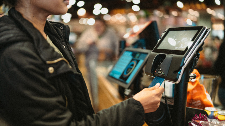 Shopper paying for groceries with card.