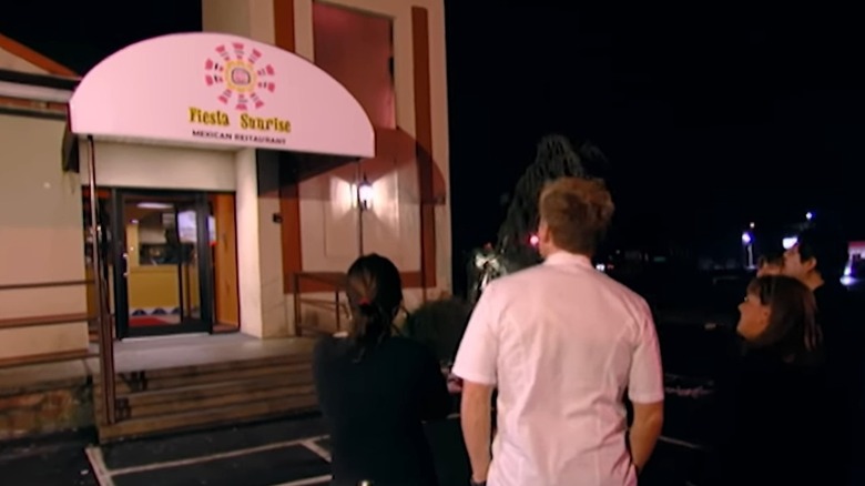 A group of people looks at the front awning and signage of Fiesta Sunrise, as shown on Kitchen Nightmares