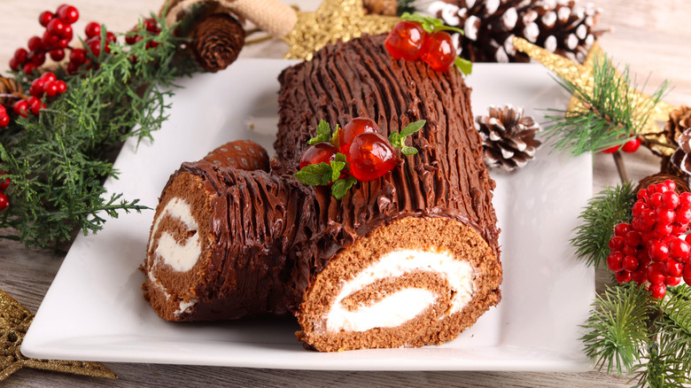Yule log cake with cherry decorations