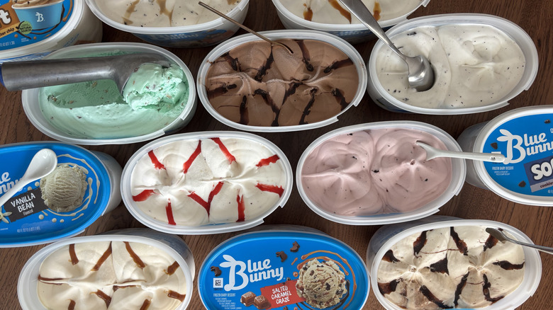 cartons of Blue Bunny ice cream with lids off, with spoons stuck into ice cream