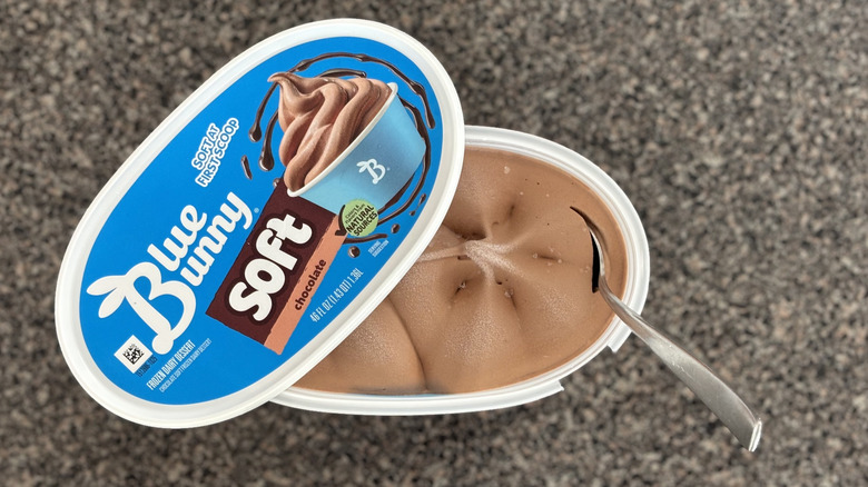 soft serve chocolate ice cream container with spoon stuck into it