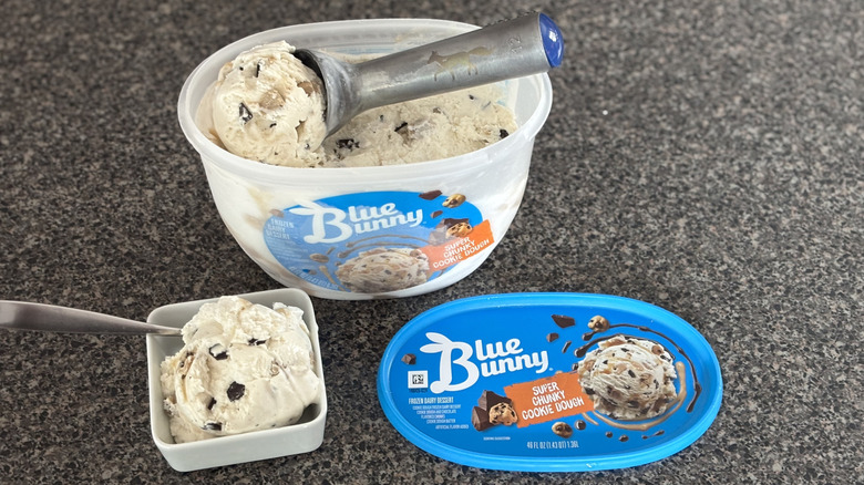 ice cream scoop with cookie dough ice cream, with bowl of ice cream in front