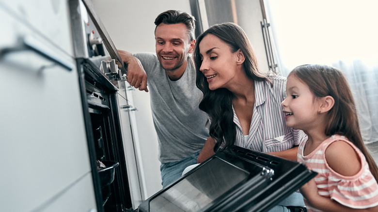 family peeking at cake in oven