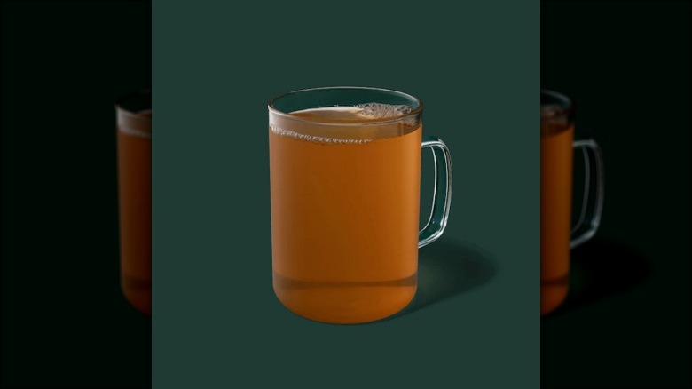 cup of hot tea on green background