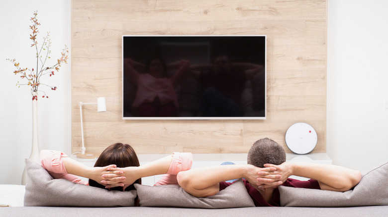 A couple on the couch getting ready to watch TV