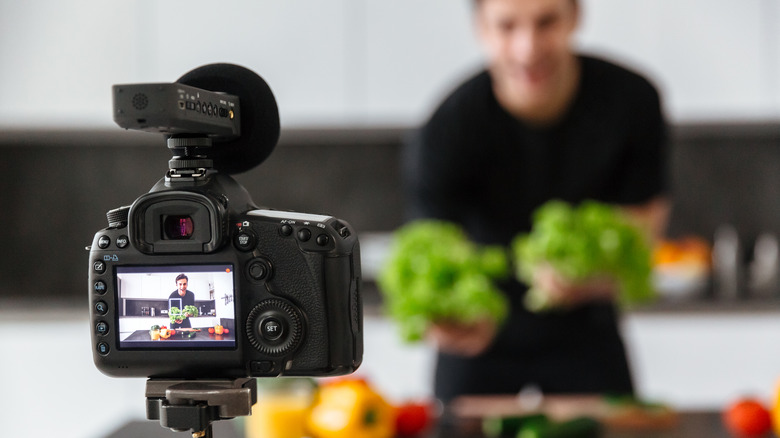 A representational image of a chef filming a video