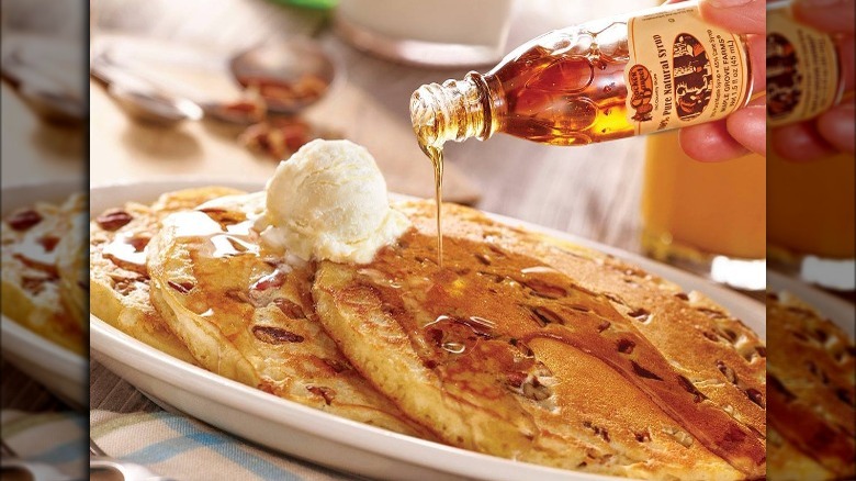 Pouring syrup on Cracker Barrel pecan pancakes