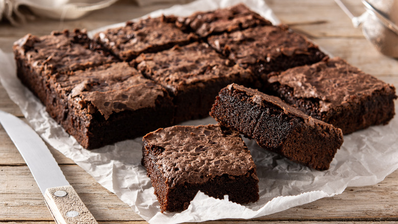 Brownie squares on a sheet of wax paper.