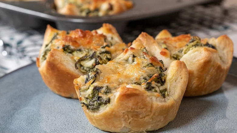 close up of three spinach artichoke bites baked in puff pastry on plate