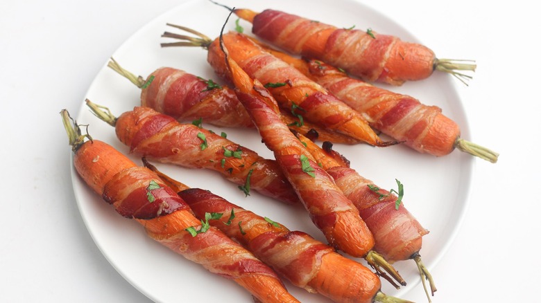 Bacon wrapped carrots on black plate