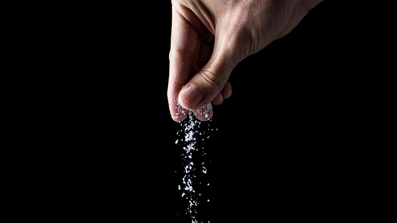 person sprinkling salt 