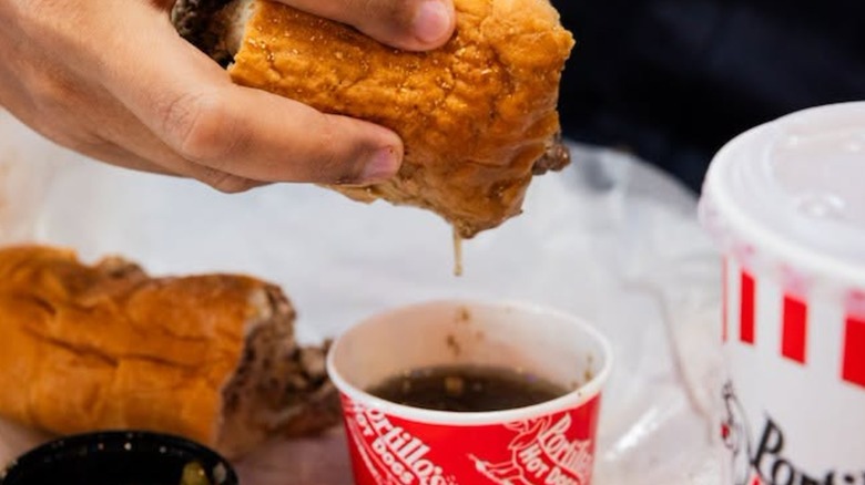 Hand dipping bread into gravy