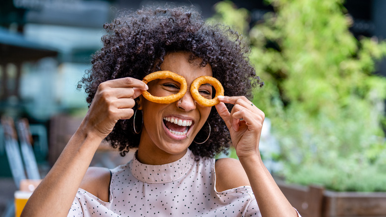 woman playing with onion rings