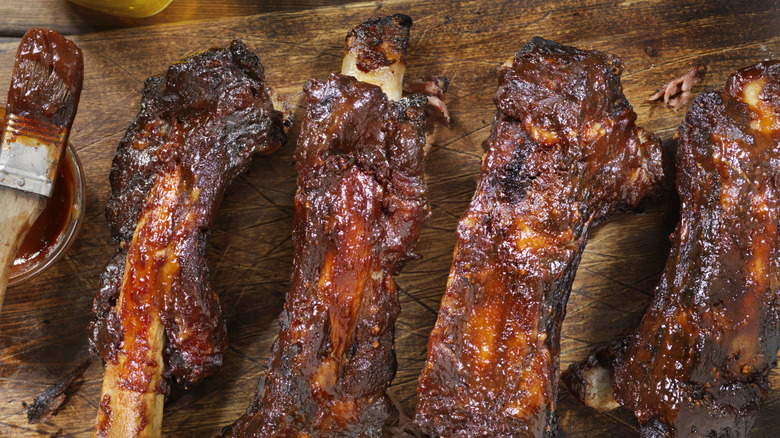 Roasted barbecue ribs laid on a row on a cutting board