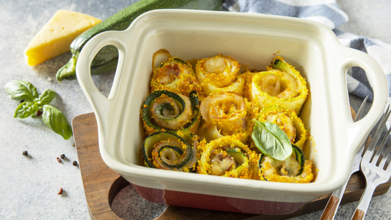 Cheese, bacon, and zucchini rolls in a square baking dish