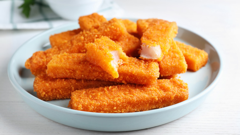 Breaded fish fingers on a blue plate