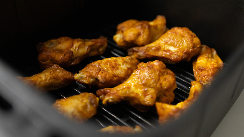 Closeup of chicken wings in an air fryer basket