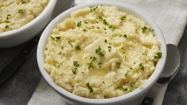 Mashed potato with a pat of melting butter in a white bowl