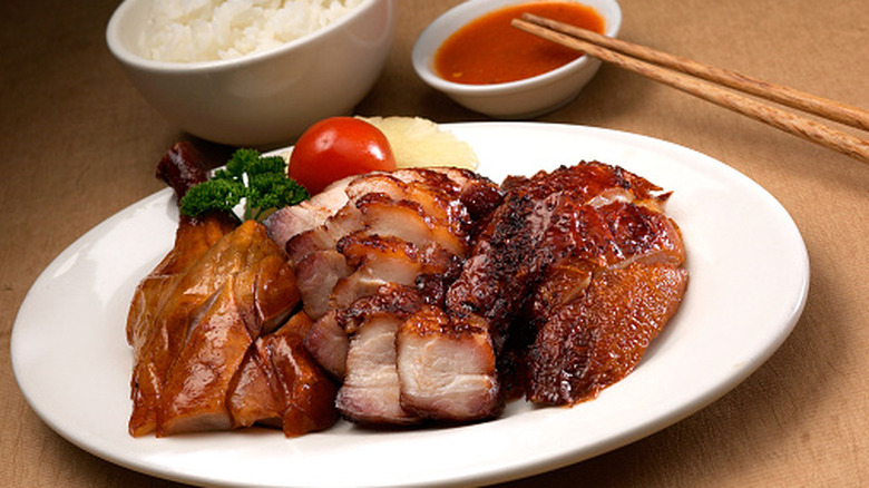 Roast chicken, pork, and duck on a white plate