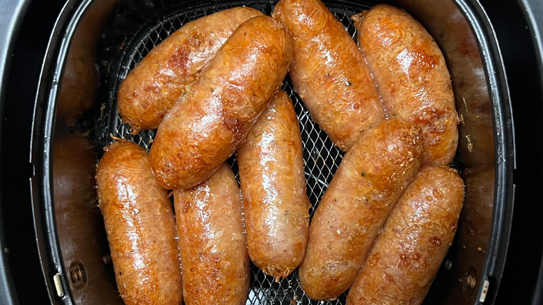 Top view of chunky sausages inside an air fryer basket