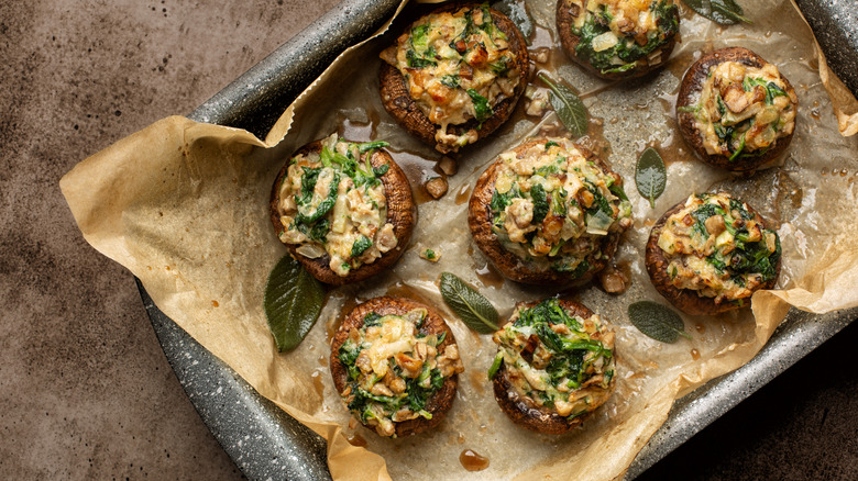 Stuffed mushrooms in a baking pan with parchment paper