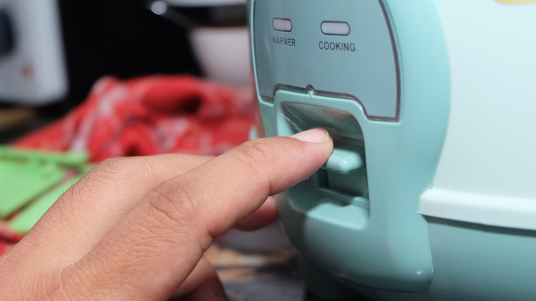 Hand activating rice cooker