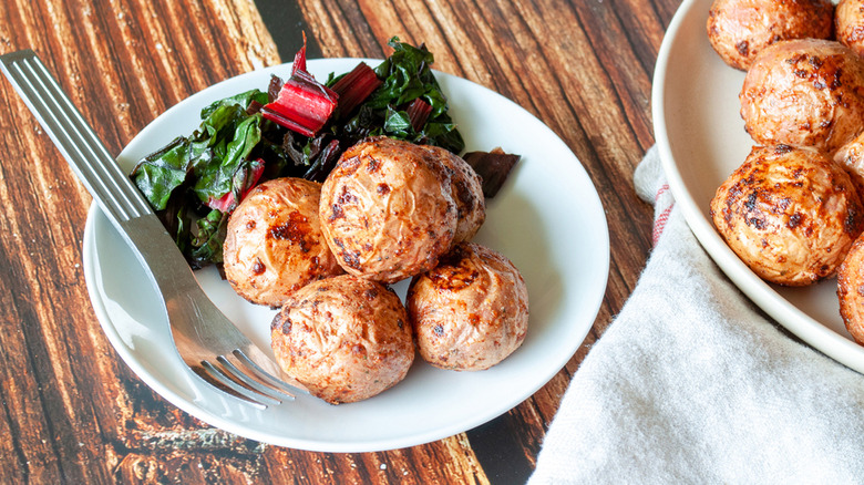 3 ingredient air fryer ranch potatoes on two white plates on a wooden table