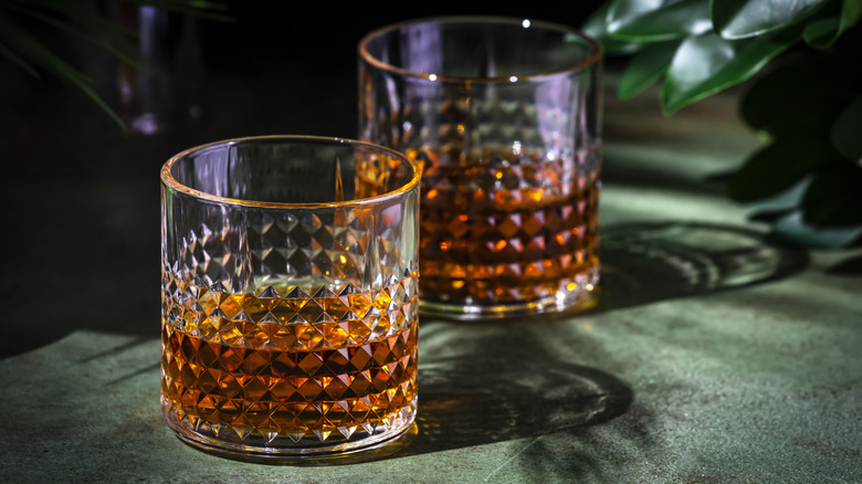 Two cocktail glasses filled halfway with dark liquor.