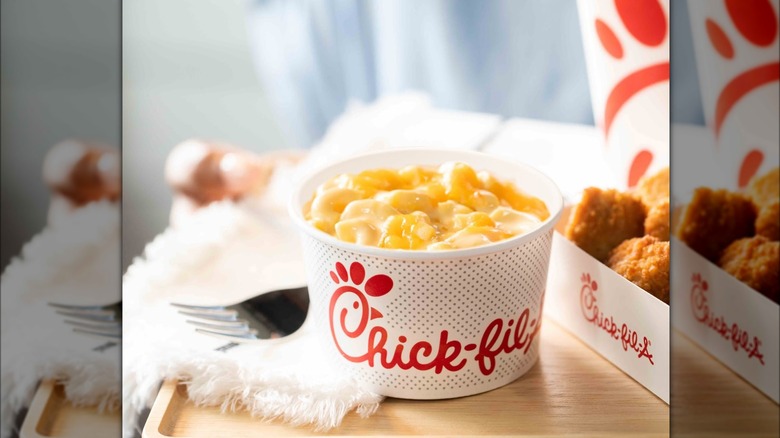 Cup of Chick-fil-A mac and cheese next to box of chicken nuggets.